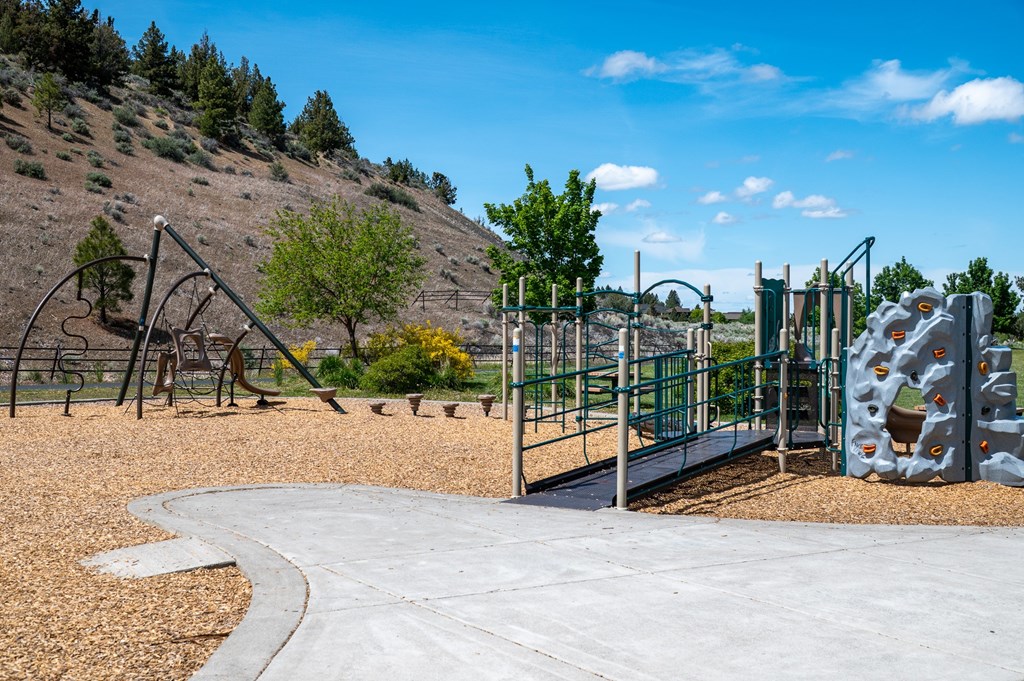 A playground with a slide, swings, and climbing wall.