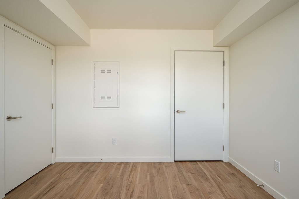 A room with two doors and a white framed window.