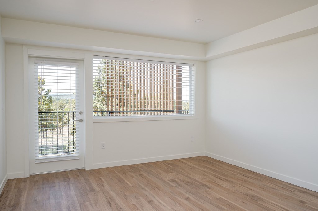 A room with a white door and a window with blinds.