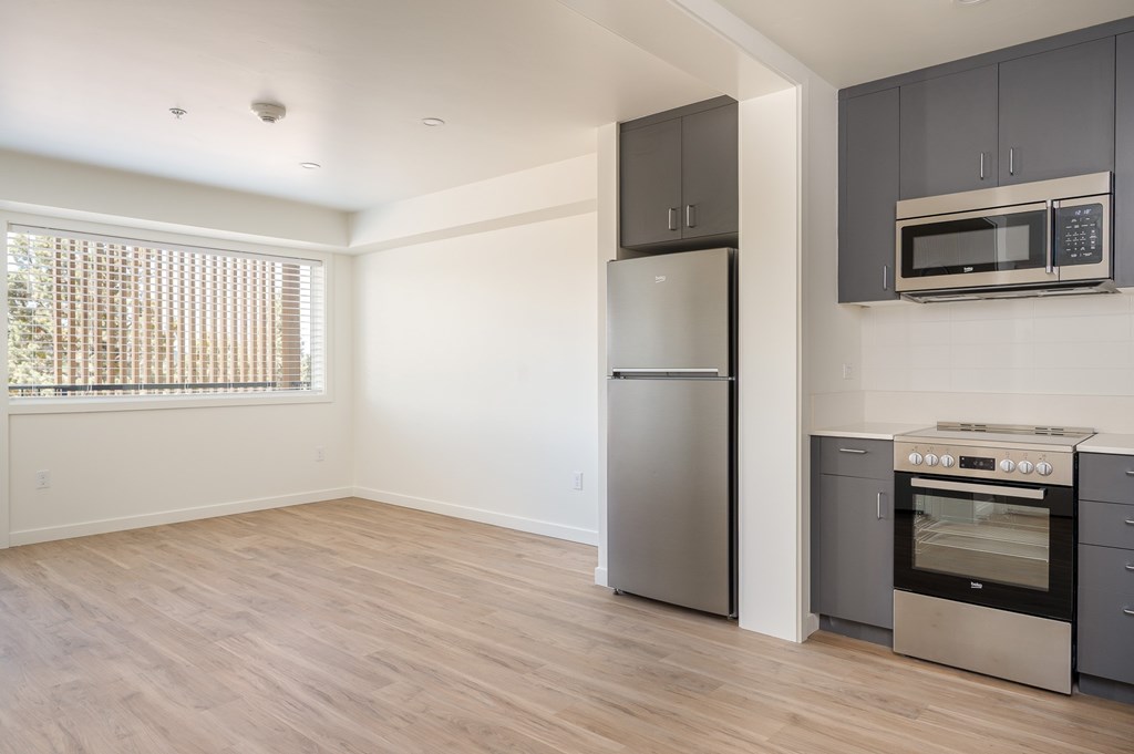 A kitchen with a stainless steel refrigerator, oven, and microwave.
