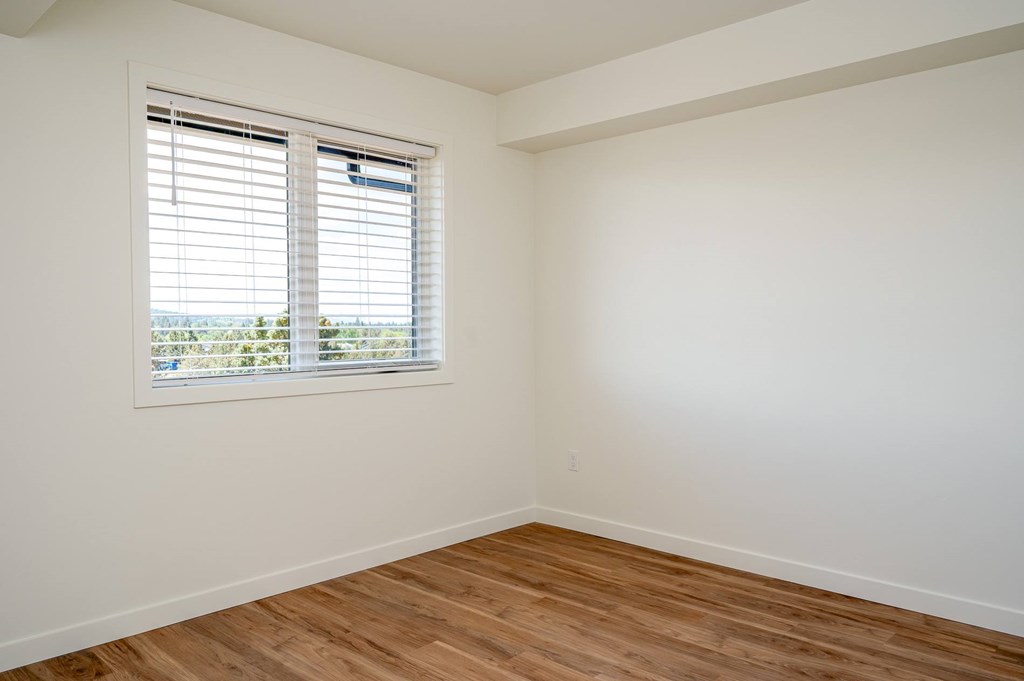 A room with a window and wooden flooring.