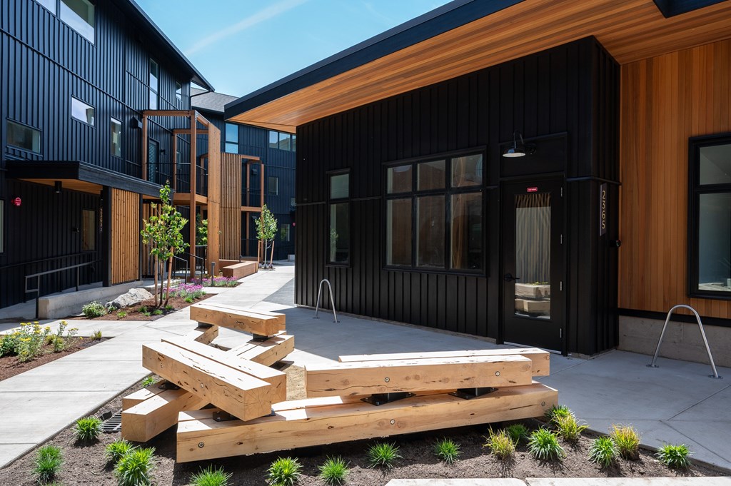 A modern building with a black exterior and wooden accents.