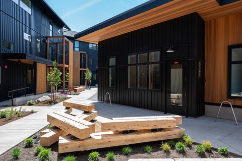 A modern building with a black exterior and wooden accents.