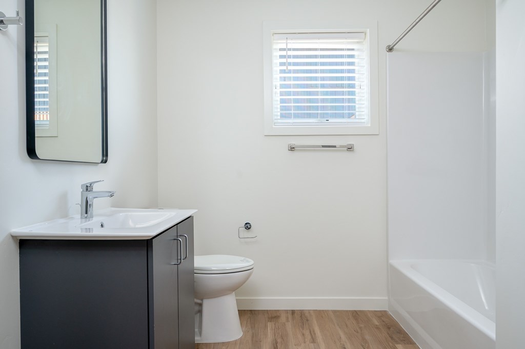 A bathroom with a toilet, sink, and bathtub.