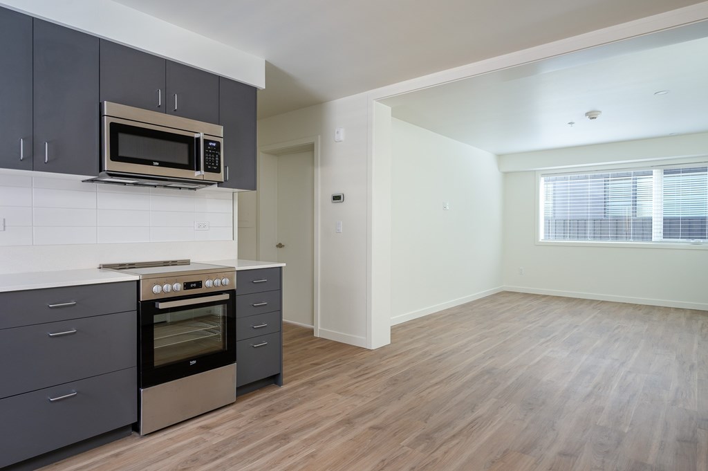 A kitchen with a stove top oven and microwave above it.