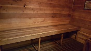 the sauna has a wooden bench and a wooden floor