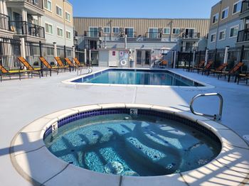 a hot tub is next to a pool in an apartment building