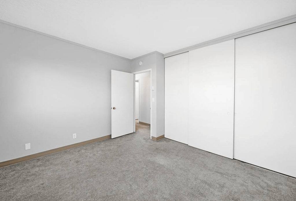 a bedroom with white walls and doors and carpet