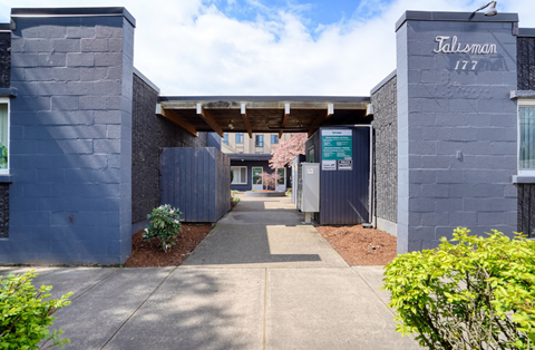 the entrance to a building with a blue wall and a sidewalk