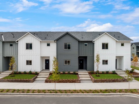 A row of modern houses with white and grey exteriors.