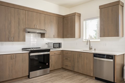 A kitchen with wooden cabinets and stainless steel appliances.