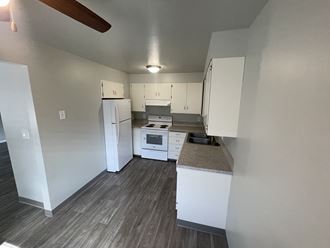 an empty kitchen with white cabinets and white appliances