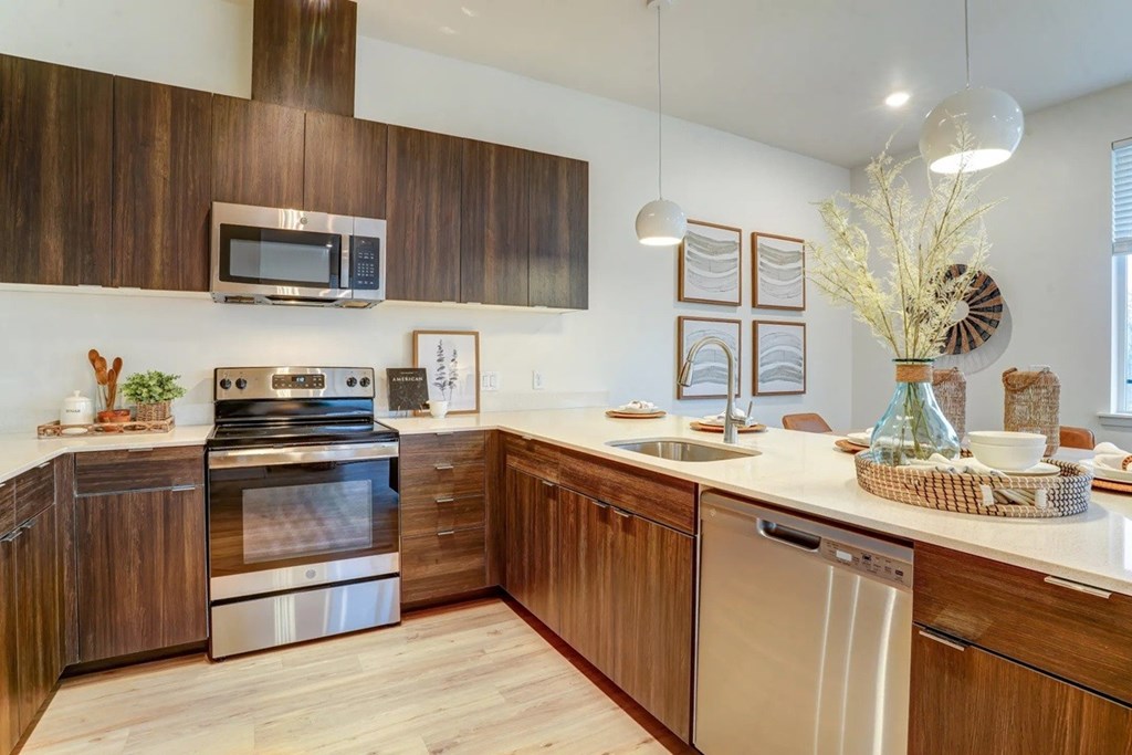 A modern kitchen with wooden cabinets and stainless steel appliances.