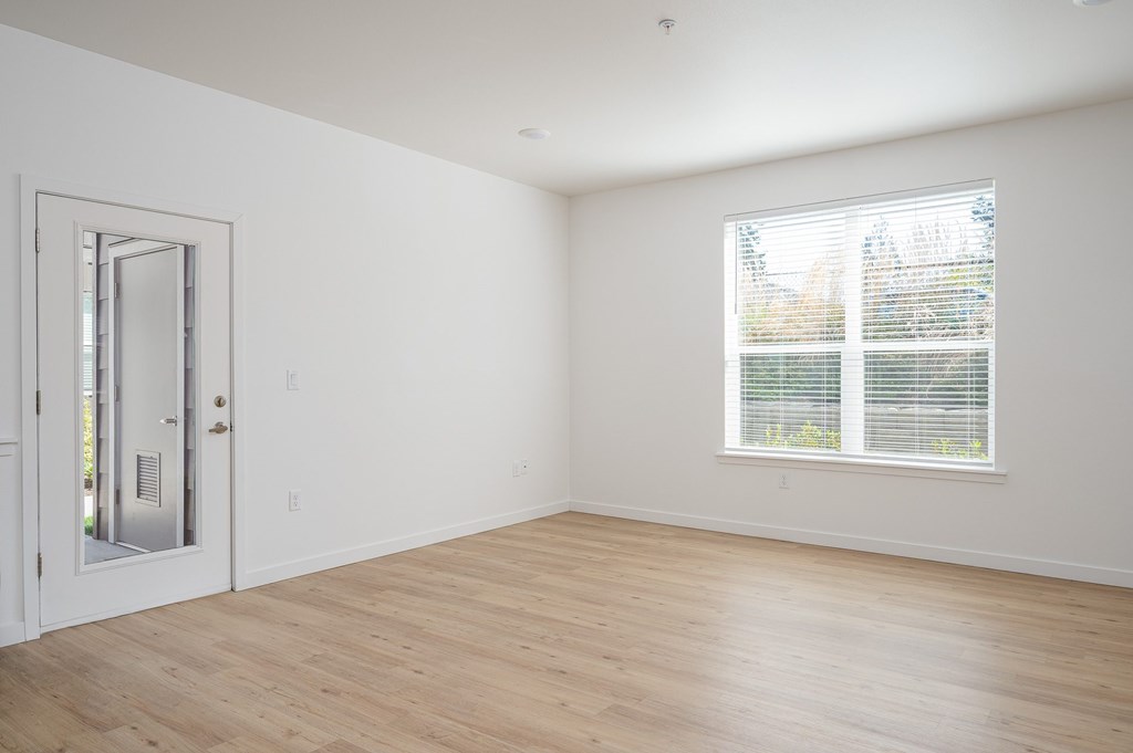 A room with a door and a window with blinds.