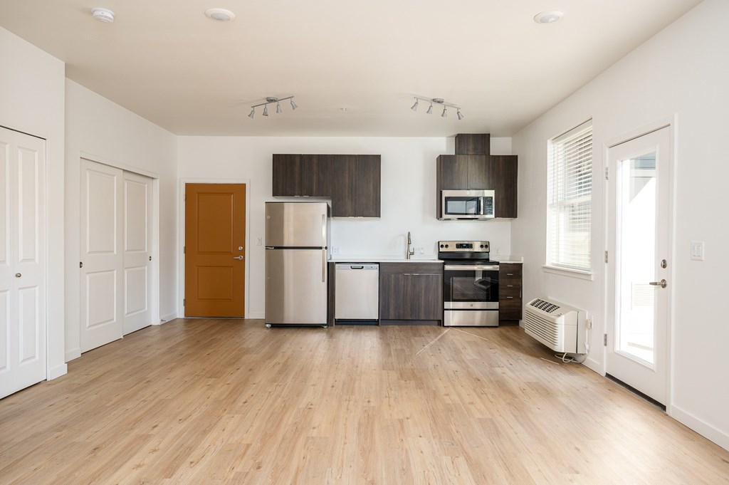 A kitchen with wooden floors and white walls.