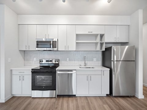 a kitchen with white cabinets and stainless steel appliances