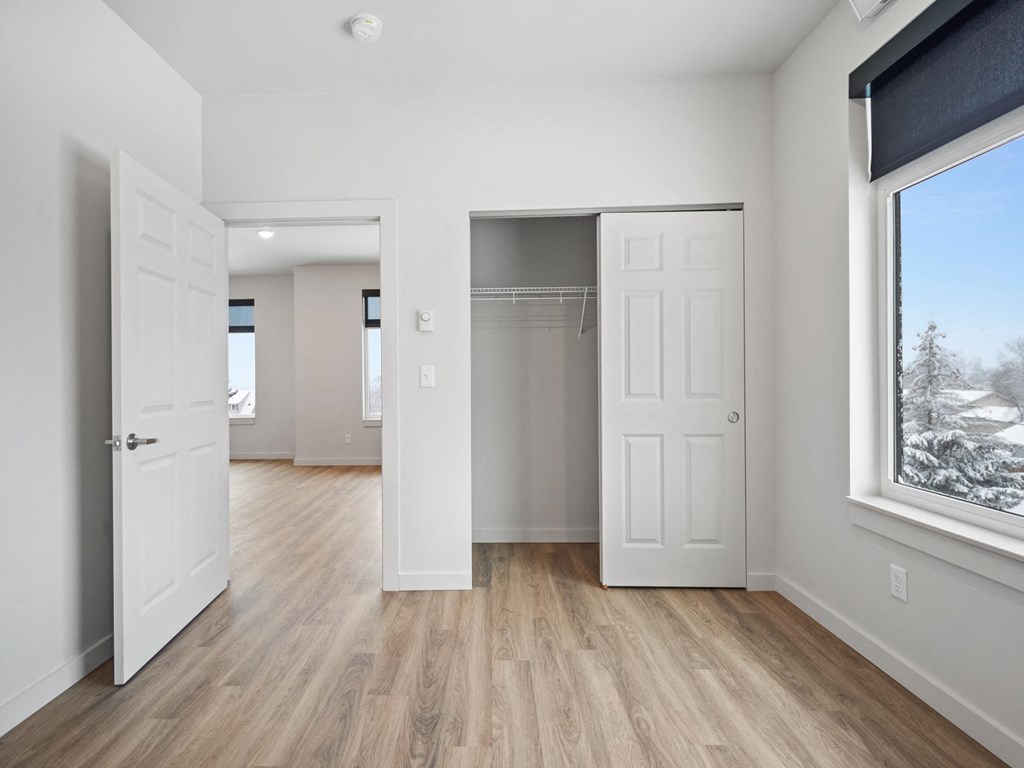 a living room with white doors and a door to a closet