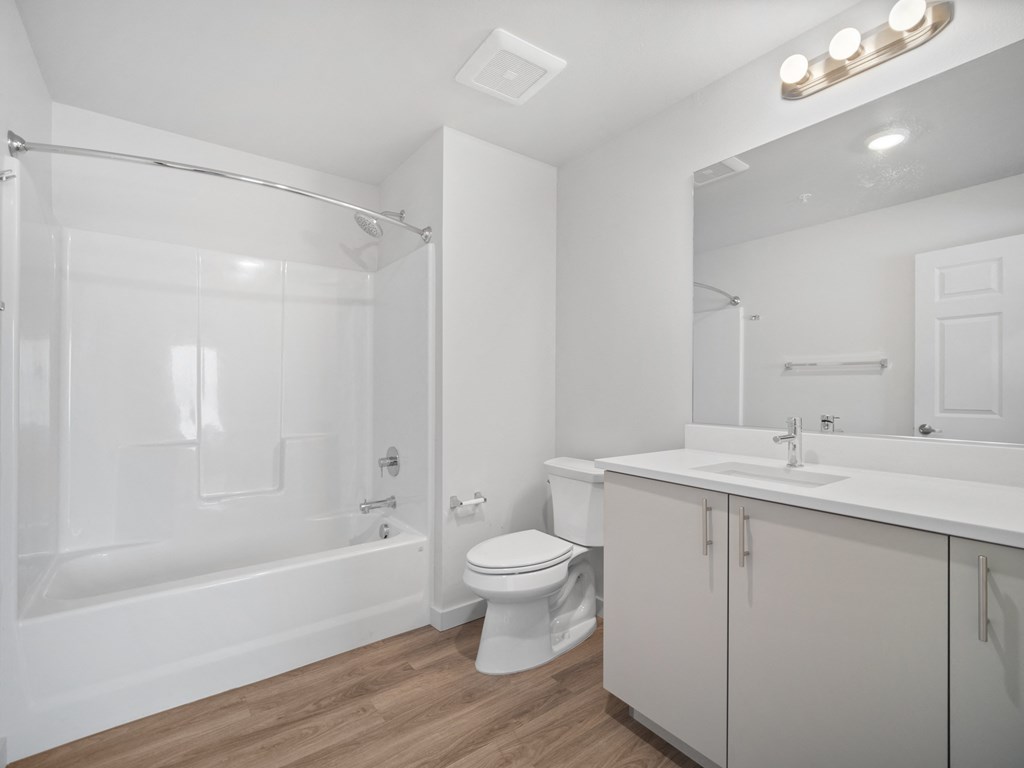 a white bathroom with a shower toilet and sink