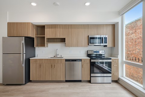 A modern kitchen with wooden cabinets and stainless steel appliances.
