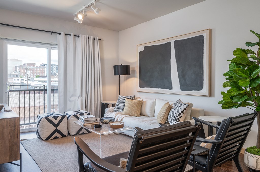 One Bedroom Apartments in Everett WA - The Waterline - Living Room with Vinyl Hardwood Flooring, Area Rug, Stylish Decor, and Sliding Doors to the Balcony