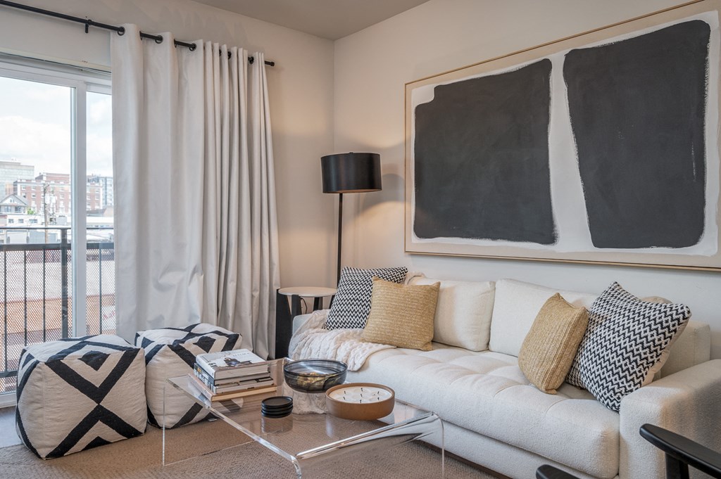 One Bedroom Apartments in Everett WA - The Waterline - Living Room with Vinyl Hardwood Flooring, Area Rug, Stylish Decor, and Sliding Doors to the Balcony