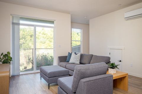 A living room with a grey couch and a wooden coffee table.