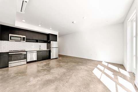 A kitchen with black cabinets and stainless steel appliances.