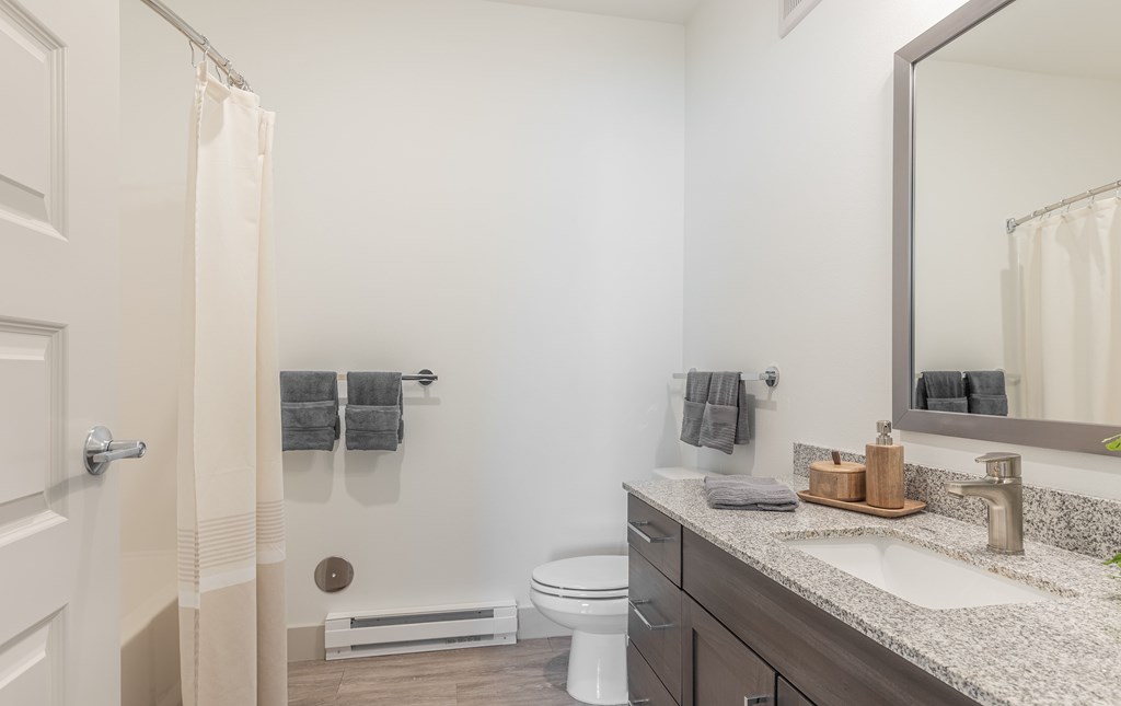 A bathroom with a toilet, sink, and shower.