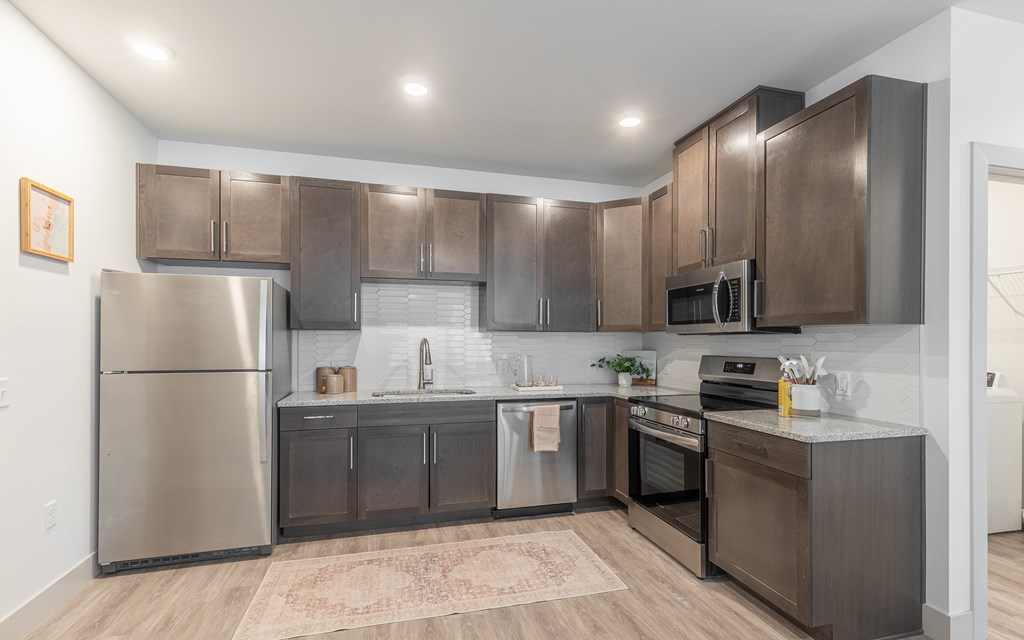 A modern kitchen with stainless steel appliances and wooden cabinets.