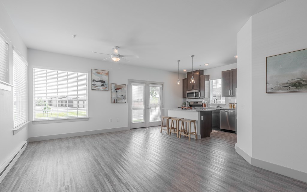 A spacious kitchen and dining area with wooden flooring and white walls.