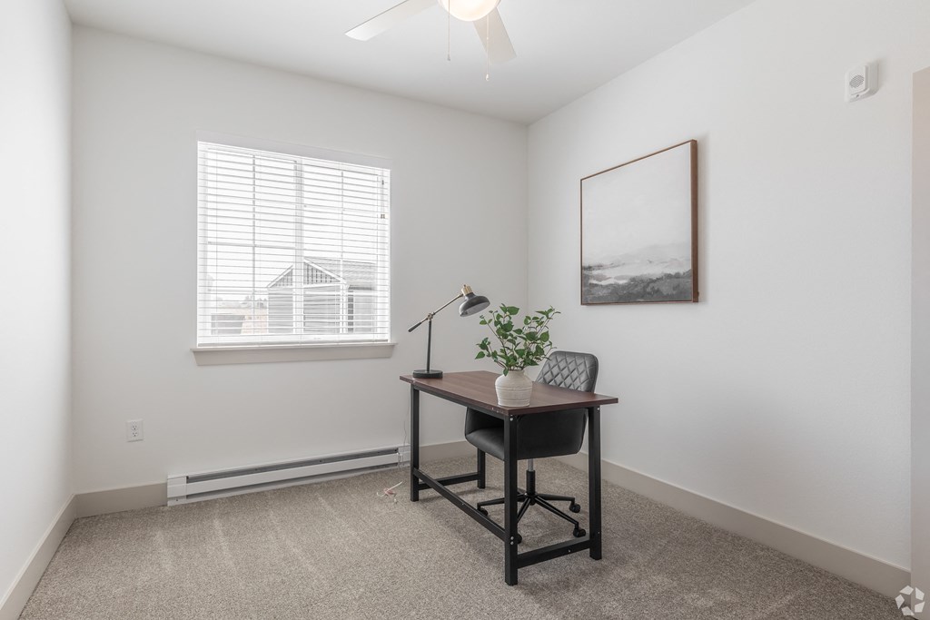 a home office with a desk and a window