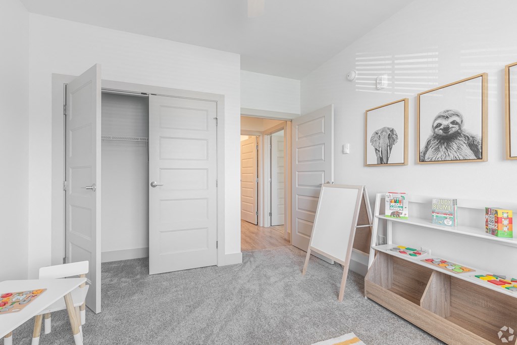 a room with an easel and paintings on the wall and a closet