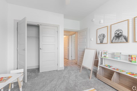 a room with an easel and paintings on the wall and a closet