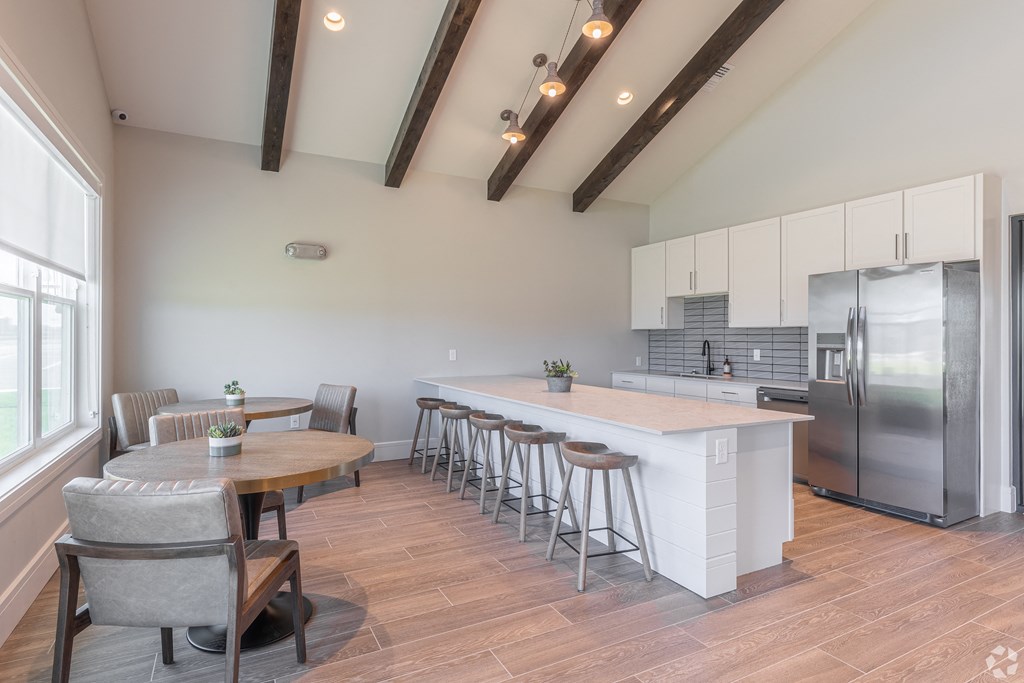 a kitchen with a large island and a table with chairs