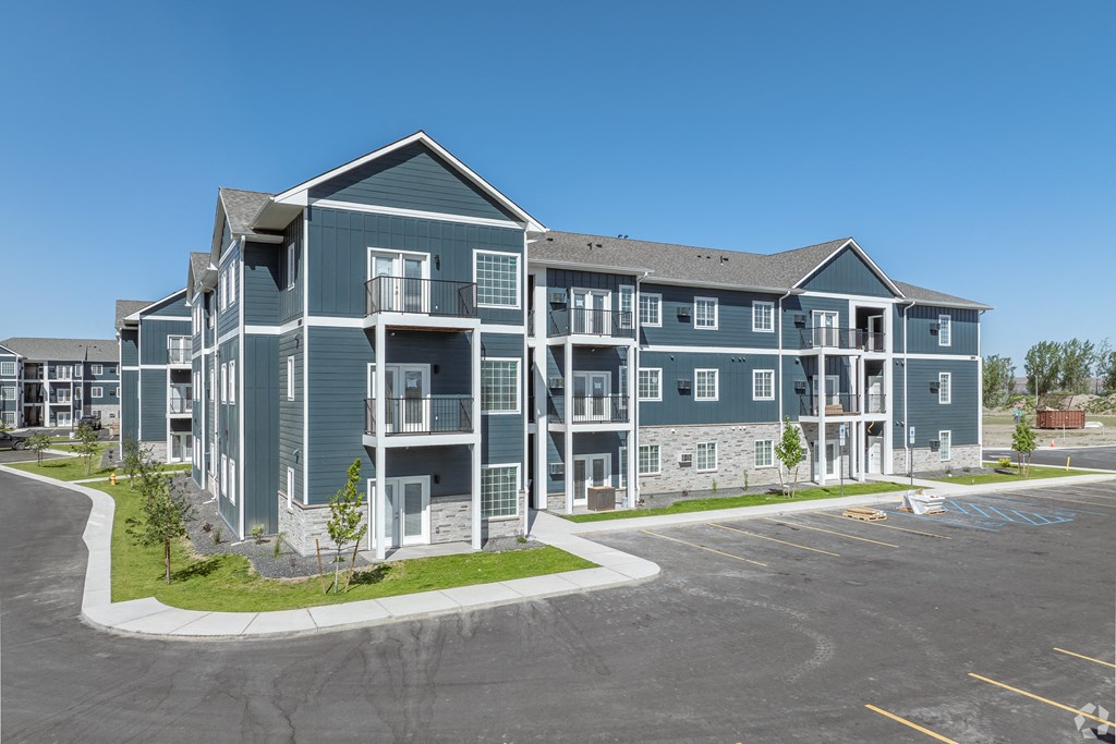 an apartment building with a parking lot and a street