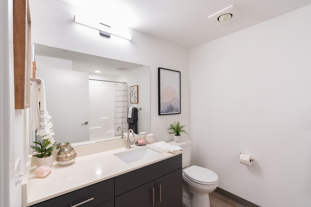 A bathroom with a white sink and a white toilet.