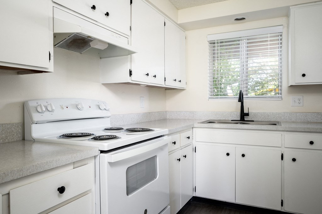 a kitchen with white appliances and white cabinets