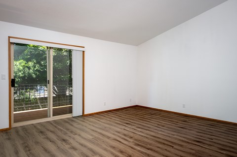 A room with a sliding glass door leading to a backyard.