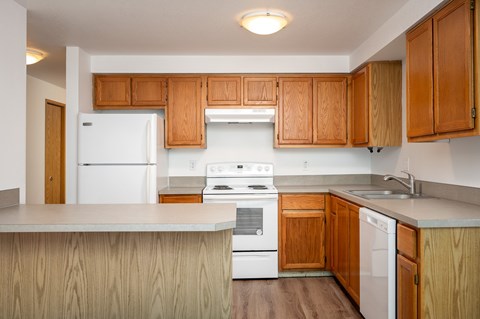 A kitchen with wooden cabinets and white appliances.