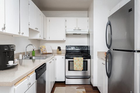 A modern kitchen with white cabinets and stainless steel appliances.