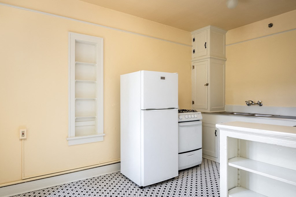 a kitchen with a white refrigerator freezer next to a stove top oven