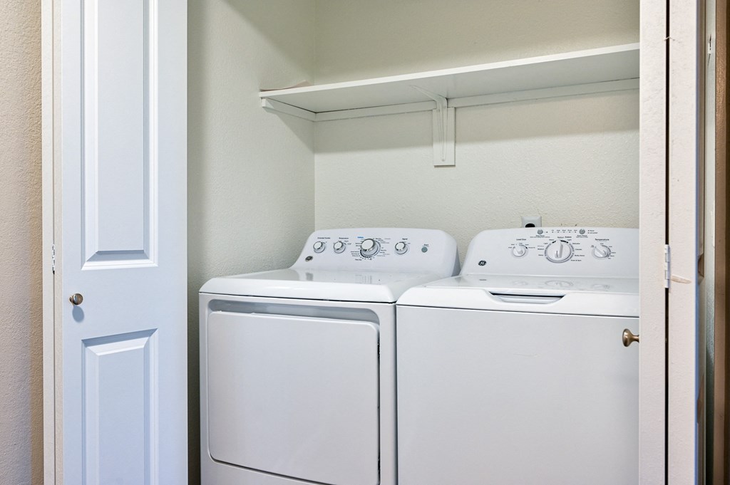 a washer and dryer in a laundry room with a white door