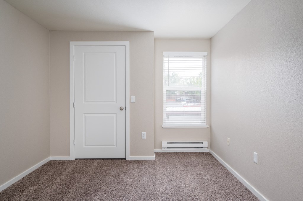 an empty room with a white door and window