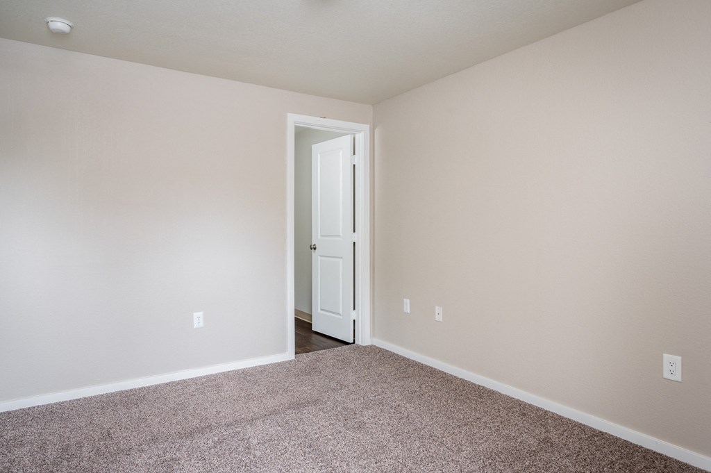 an empty room with carpet and a white door