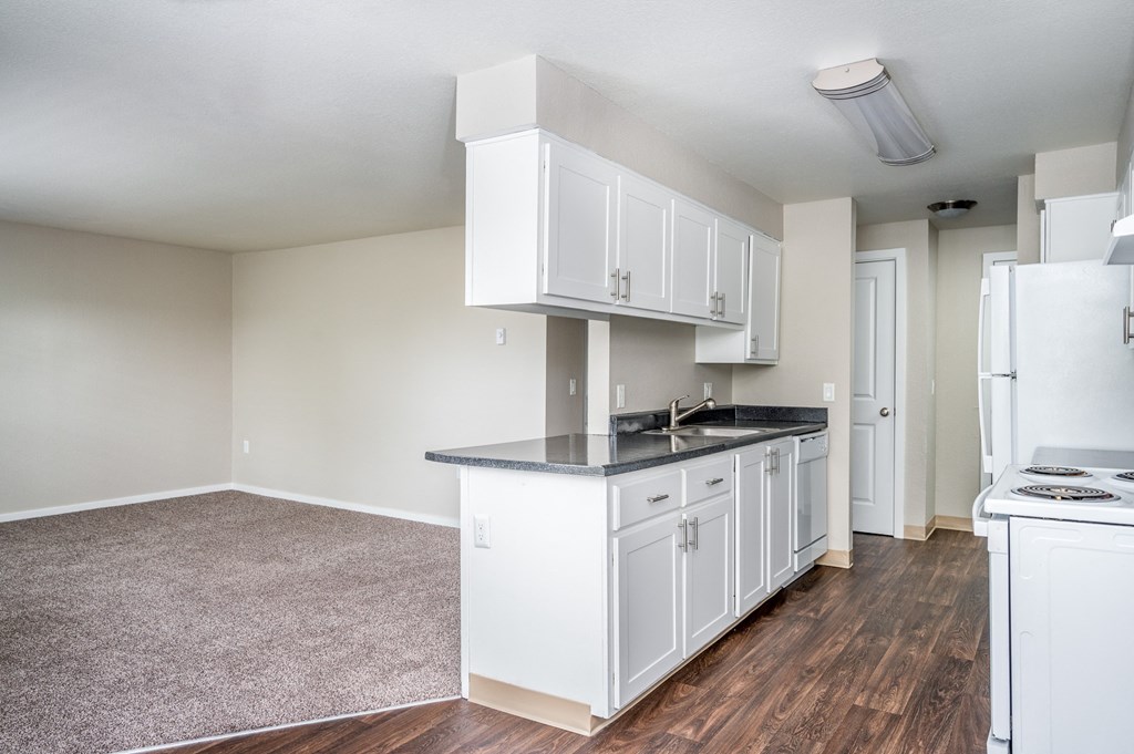 an empty kitchen with white cabinets and a counter top