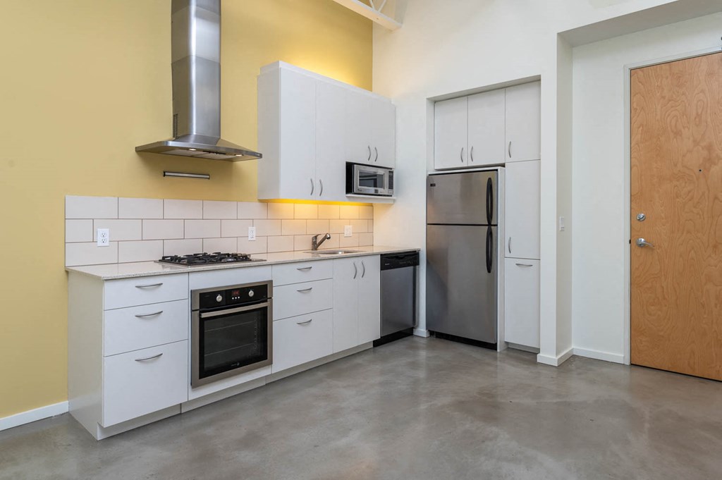 a kitchen with white cabinets and a stainless steel refrigerator