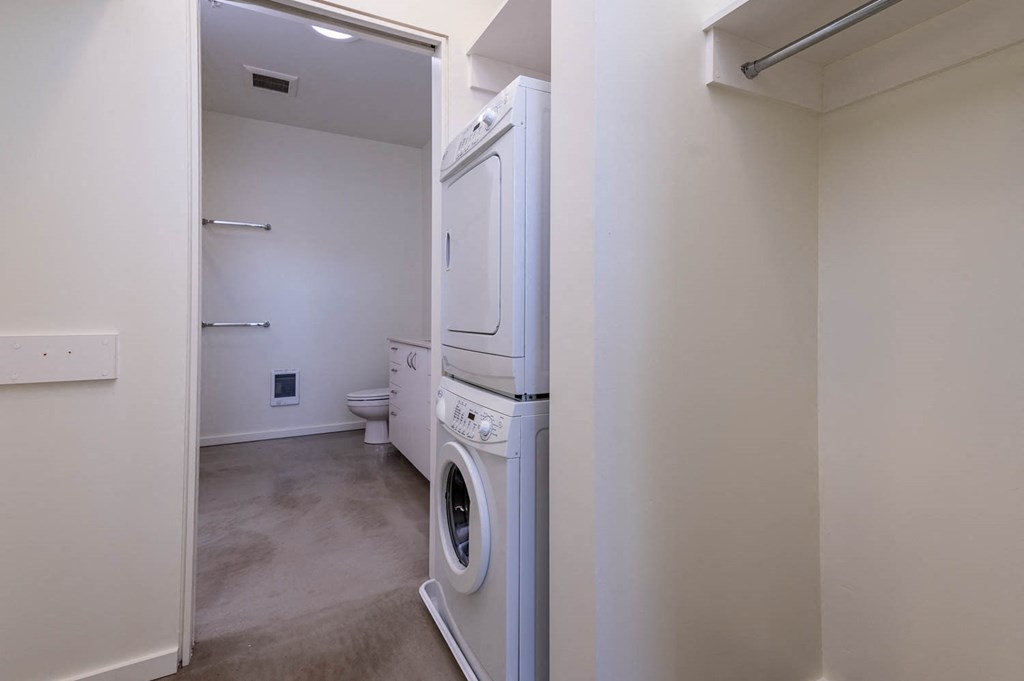 a laundry room with a washer and dryer and a toilet