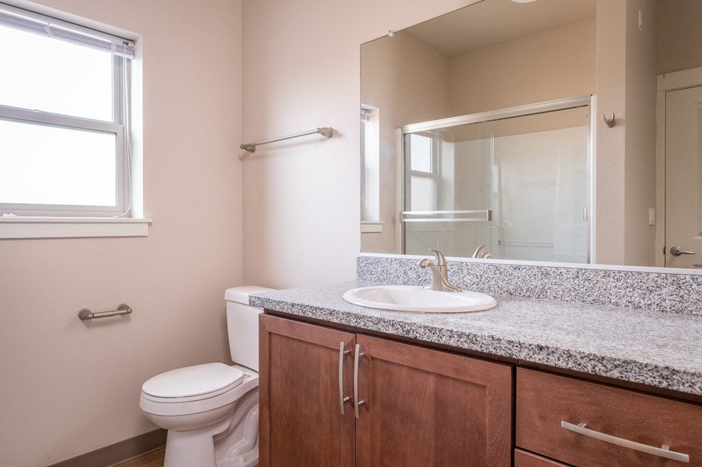 an empty bathroom with a toilet sink and mirror
