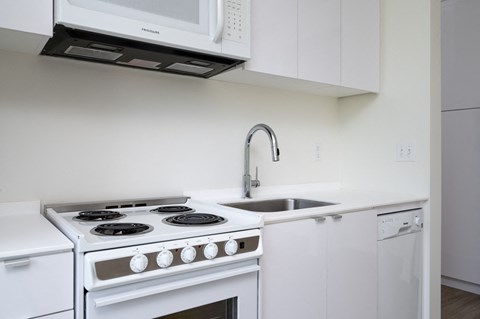 a kitchen with white appliances and a sink and white cabinets