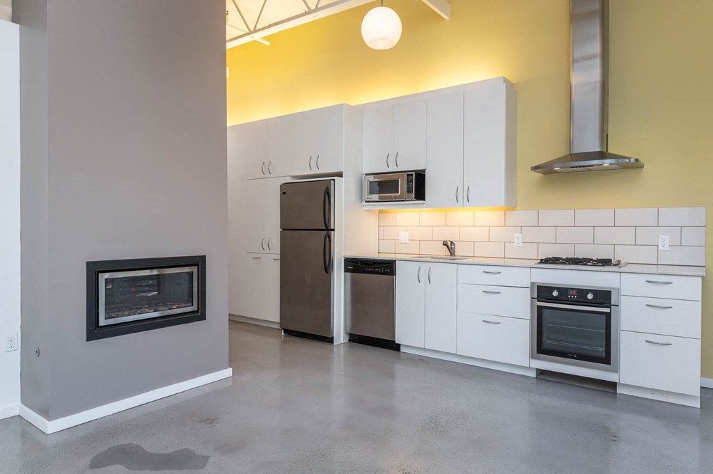 a kitchen with white cabinets and a fireplace